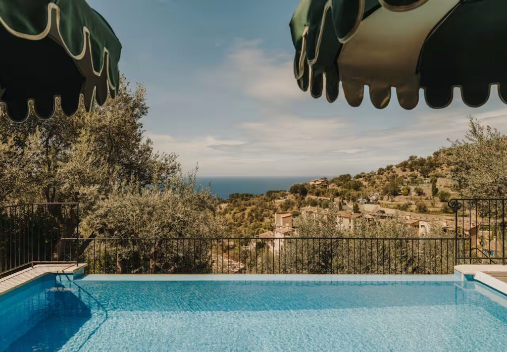 view over a pool with green foliage and dark green umbrellas